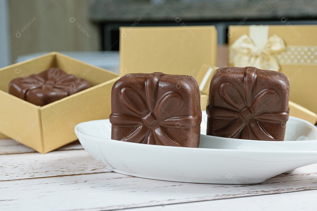 Closeup de bolos de mel brasileiro. Ao fundo, presente dourado