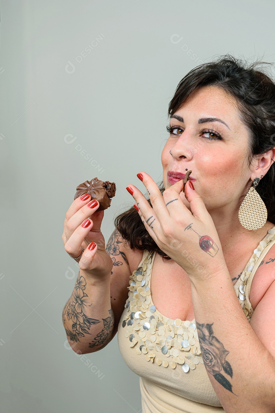 Mulher tatuada comendo um pedacinho de bolo de mel brasileiro