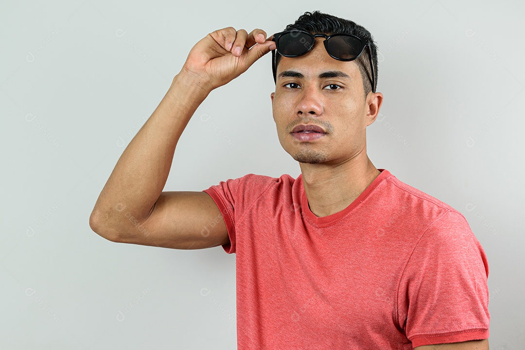 Brasileiro de 28 anos, olhando para a câmera e levantando seu óculos