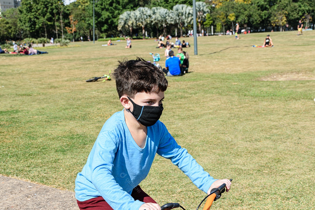 Aproximação de uma criança de 8 anos, em um dia ensolarado, andando de bicicleta