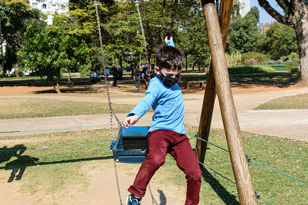 Criança de 8 anos pulando de um balanço em um dia ensolarado