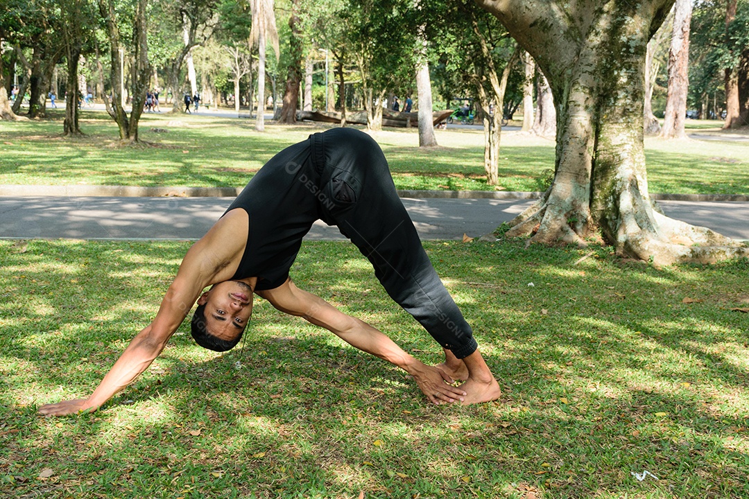 Jovem brasileiro praticando ioga em um parque público