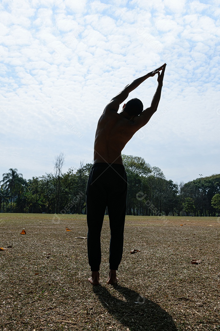 Silhueta de jovem brasileiro sem camisa fazendo alongamento