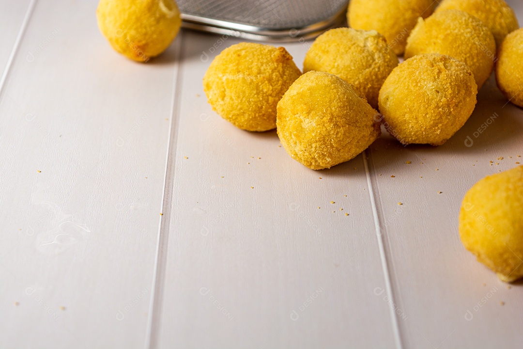 Coxinha fritas sobre uma mesa branca de madeira