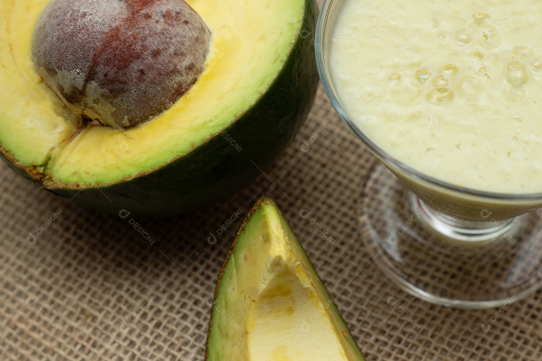 Batida de abacate e frutas em um fundo de madeira