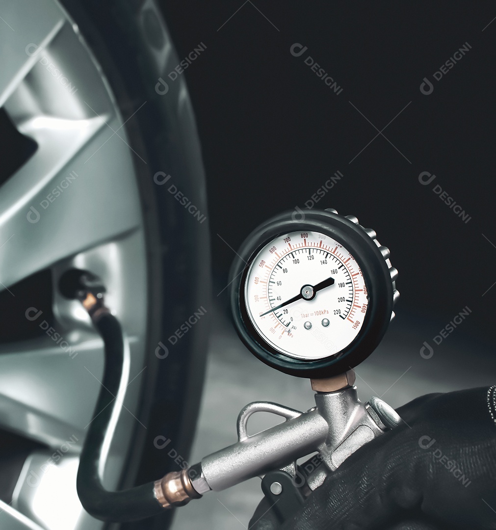 Mecânico testando a pressão dos pneus de um carro com pressão dos pneus