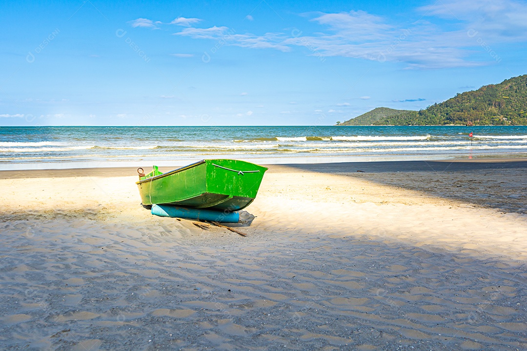 Praia tropical com barco de pesca verde na areia. praia brasileira