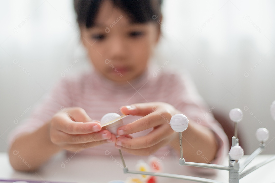 Menina asiática estuda o sistema solar na aula de geografia.