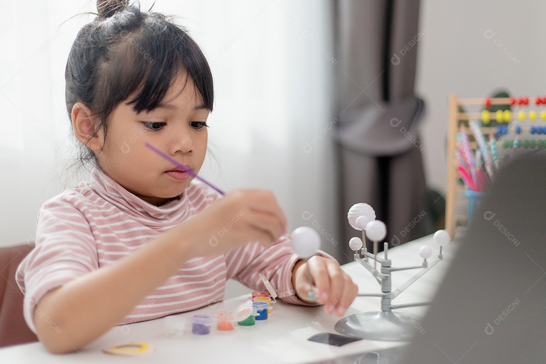 Menina asiática estuda o sistema solar na aula de geografia.