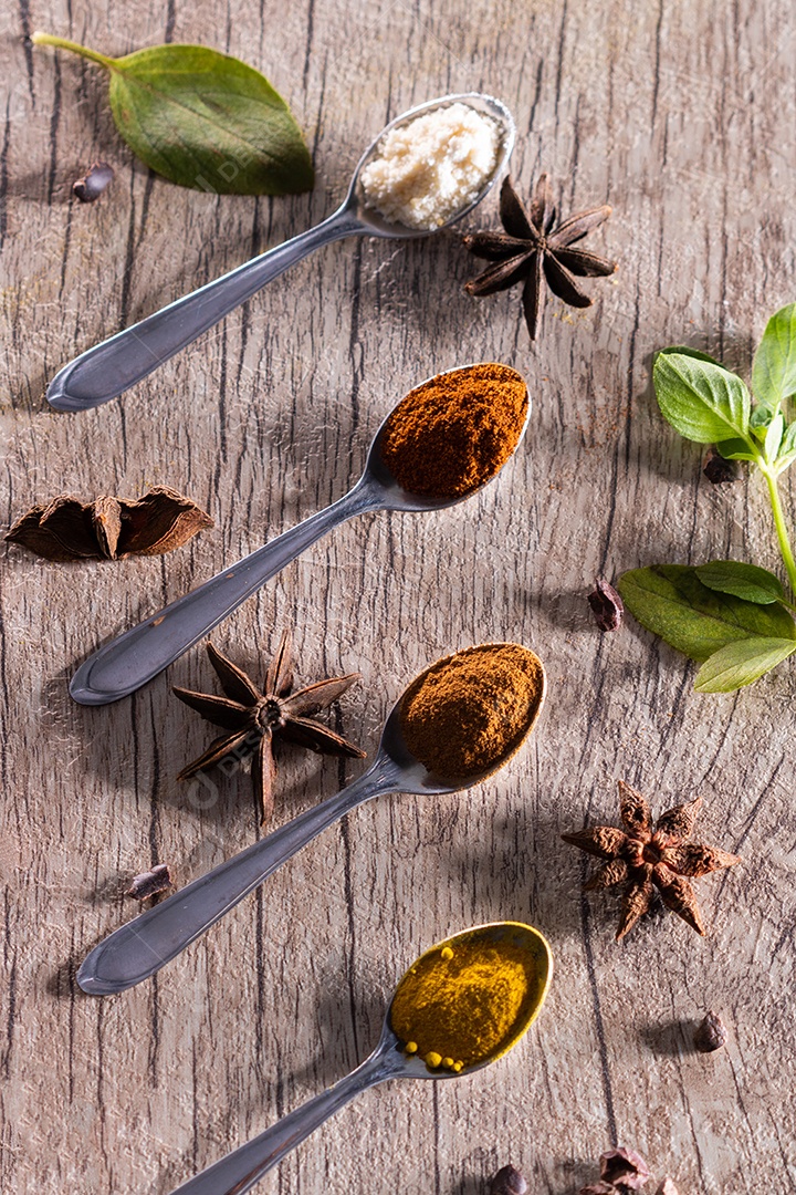 Amêndoas, canela, páprica e açafrão em pó em uma colher