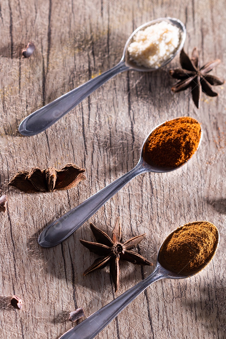 Amêndoas, canela, páprica e açafrão em pó em uma colher