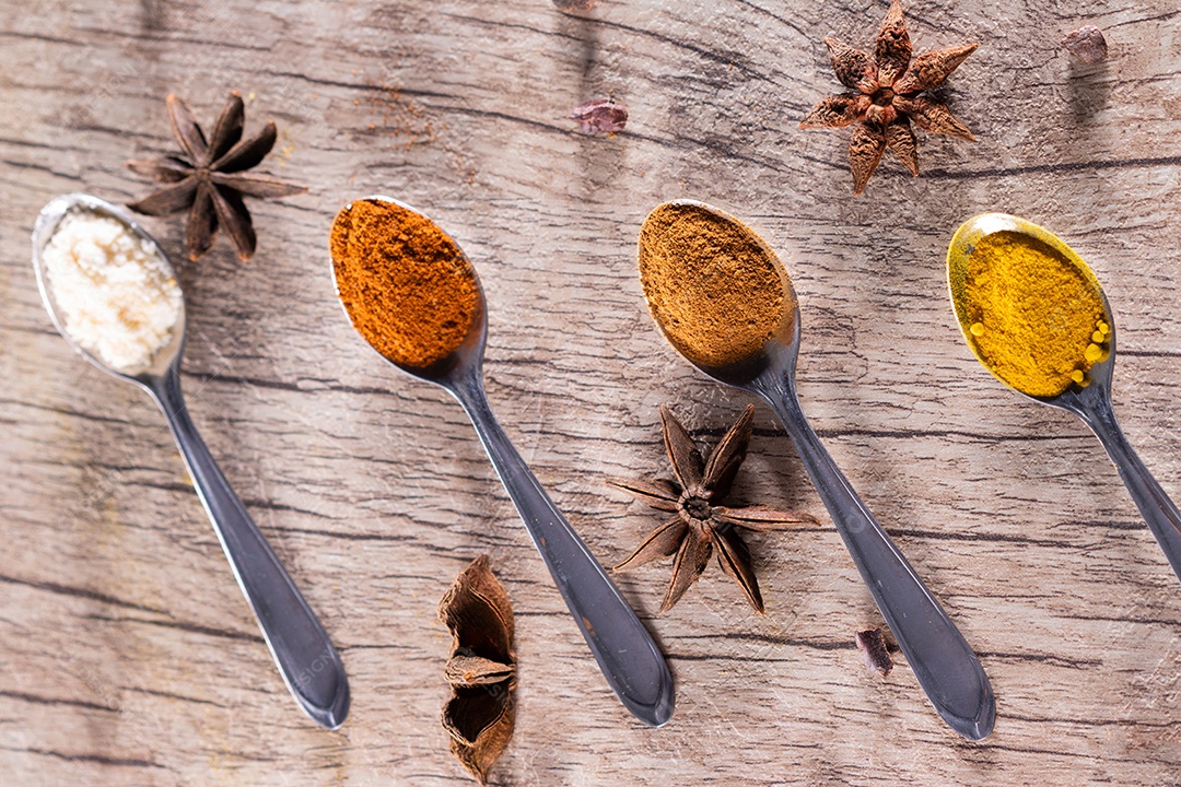 Amêndoas, canela, páprica e açafrão em pó em uma colher