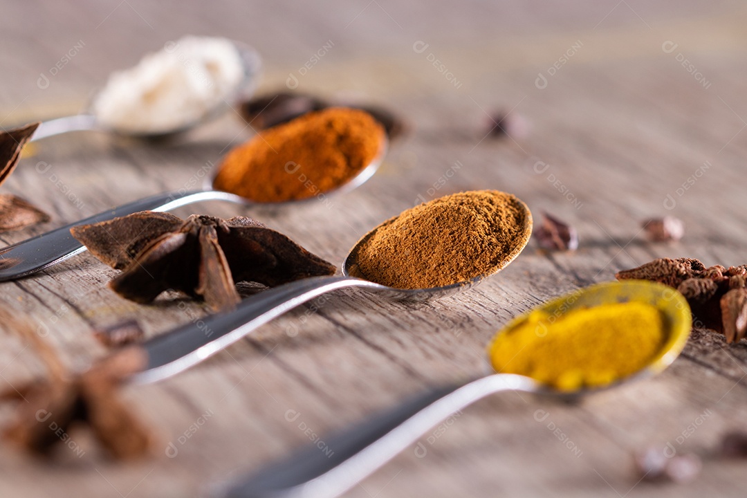 Amêndoas, canela, páprica e açafrão em pó em uma colher