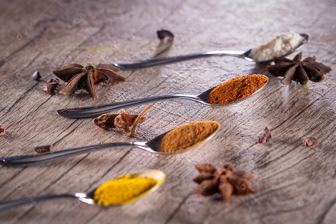 Amêndoas, canela, páprica e açafrão em pó em uma colher