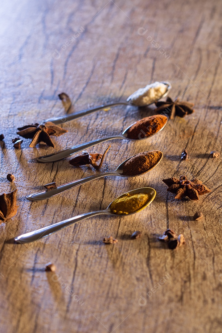 Amêndoas, canela, páprica e açafrão em pó em uma colher