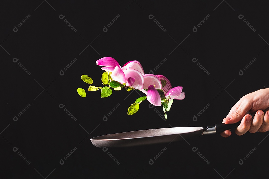 Frigideira jogando ingredientes como cebola roxa, queijo, manjericão