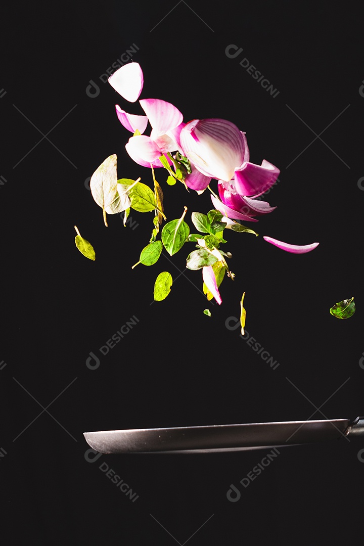 Frigideira jogando ingredientes como cebola roxa, queijo, manjericão