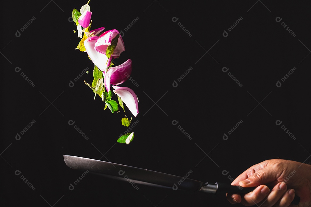 Frigideira jogando ingredientes como cebola roxa, queijo, manjericão