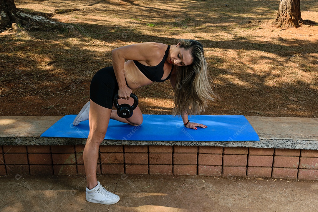 Brasileira de 42 anos treinando costas com kettlebell