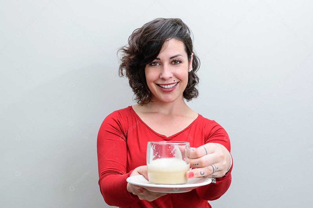Mulher brasileira sorridente segurando e oferecendo uma xícara de cappuccino