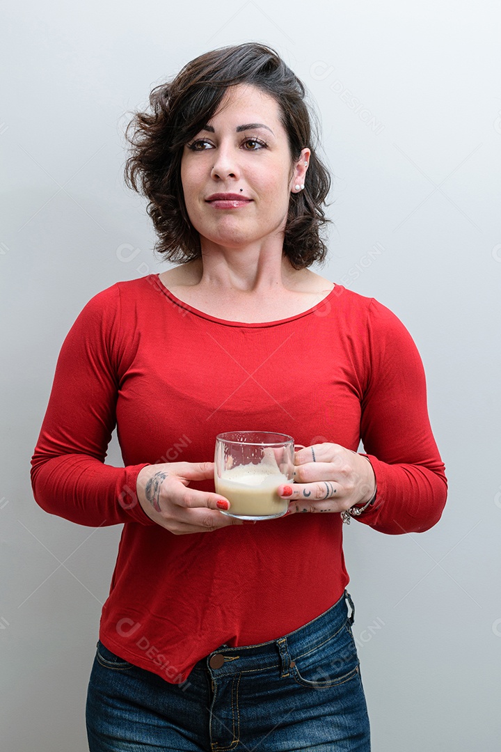 Foto espontânea. Mulher brasileira respirando fundo, segurando uma caneca de cappuccino