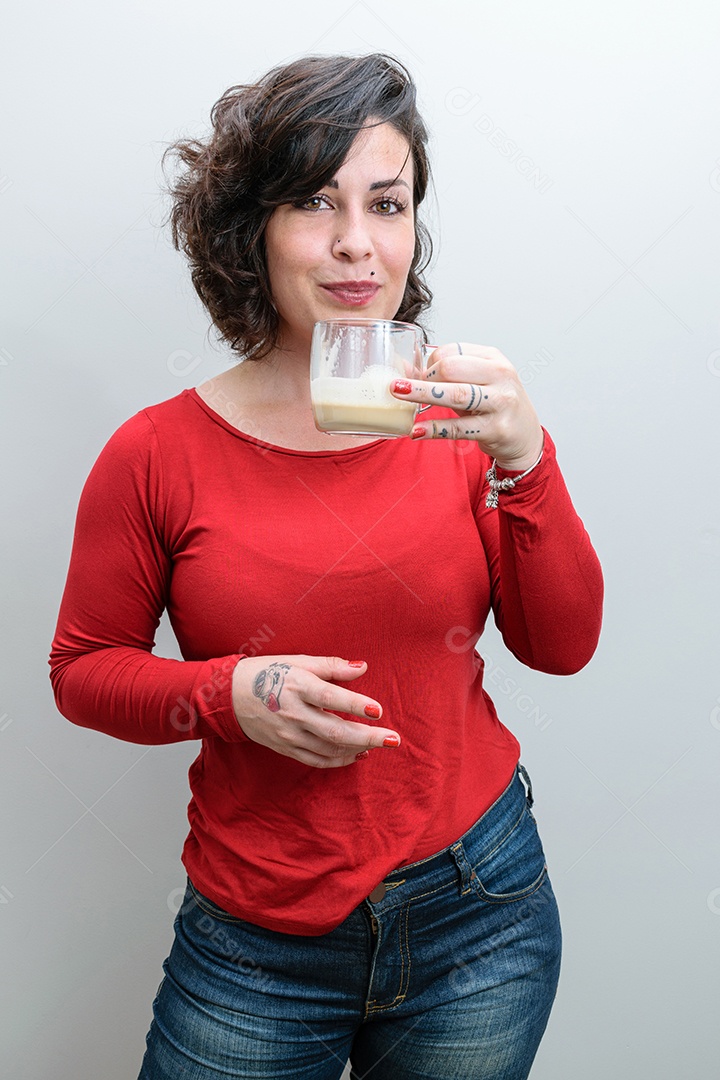 Mulher brasileira posando e sorrindo para a câmera com uma caneca de cappuccino