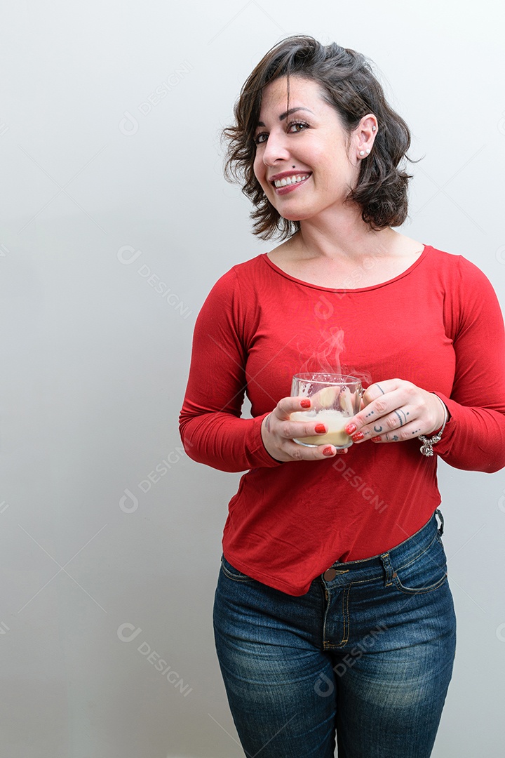 Mulher brasileira virando a cabeça e sorrindo e segurando uma caneca