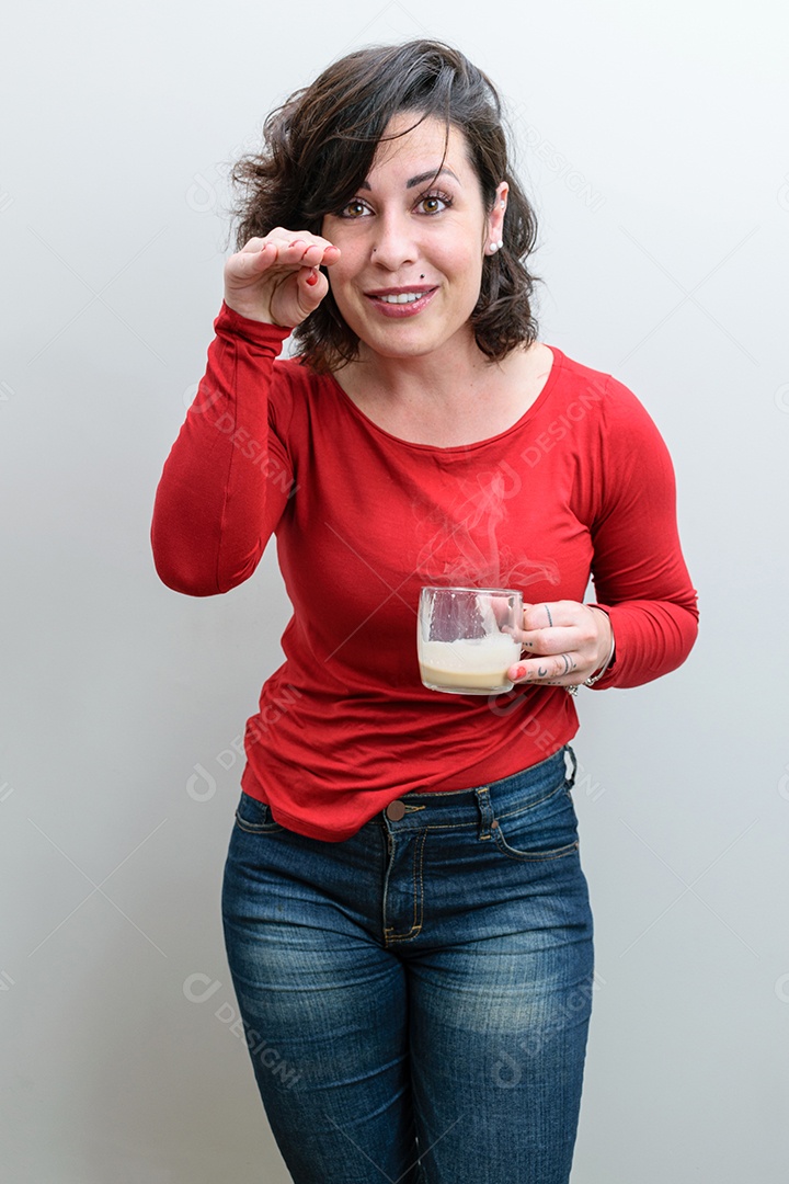 brasileira, segurando uma caneca de cappuccino, cabeça baixa