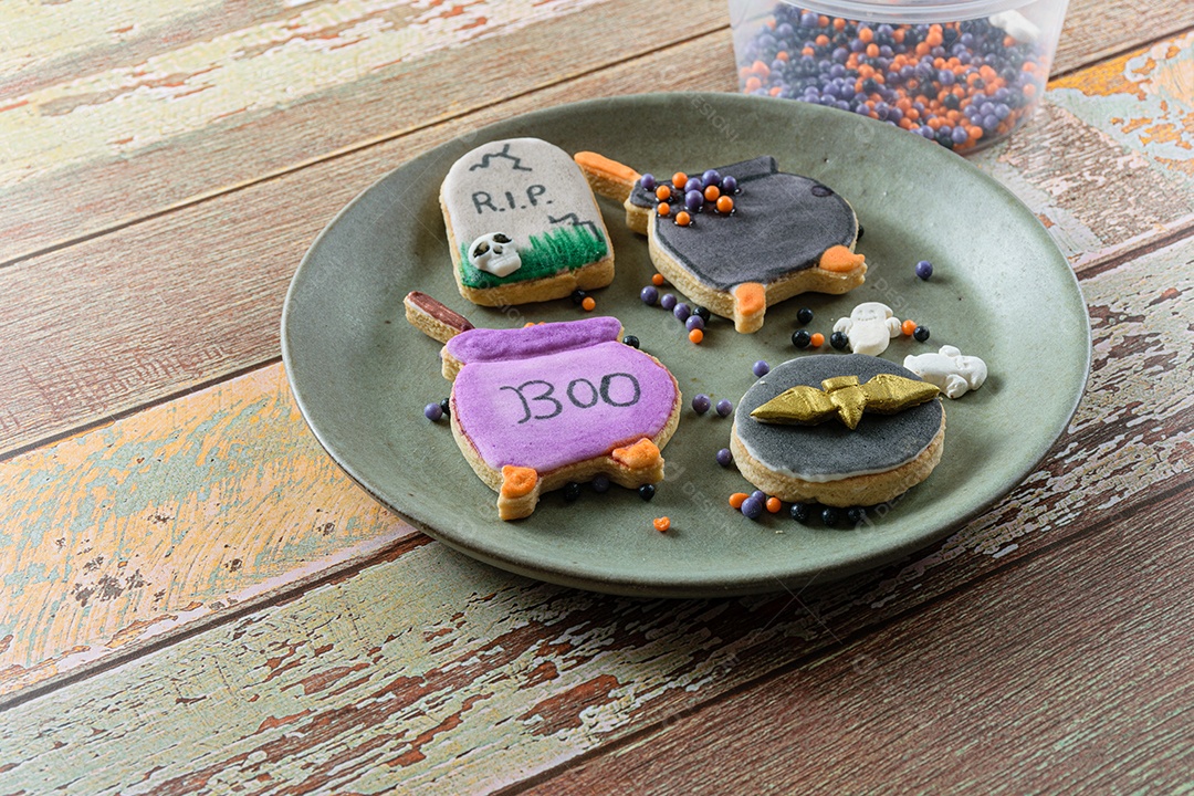 Biscoitos amanteigados em um prato, decorados com o tema Halloween.