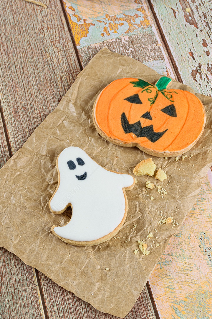 Biscoitos amanteigados com tema de Halloween ao lado de migalhas em papel pardo