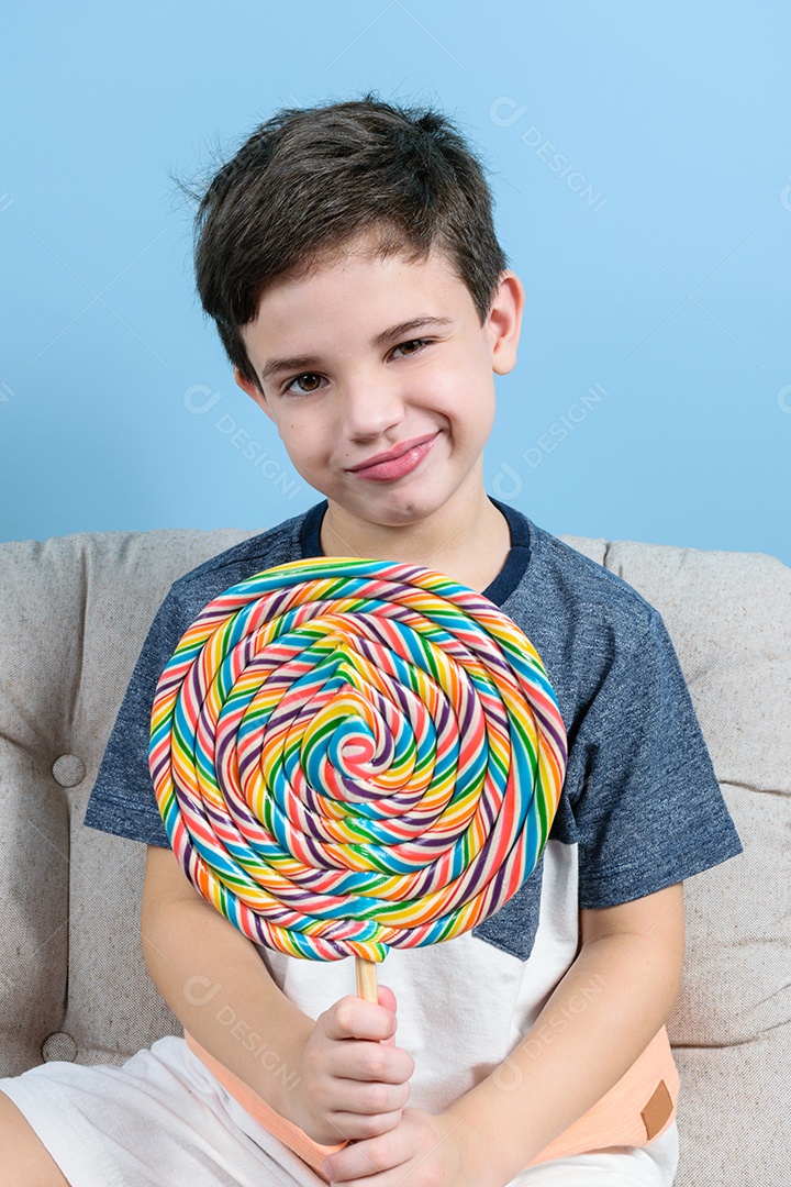 Criança de 8 anos segurando um grande pirulito colorido