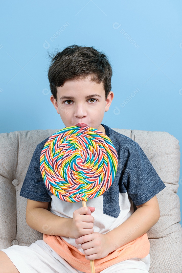 criança de 8 anos segurando um grande pirulito colorido