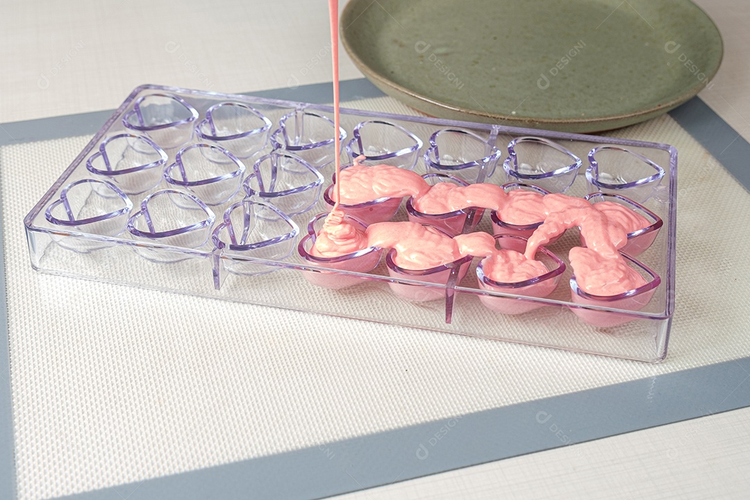 Ganache de morango sendo despejada em forma de policarbonato