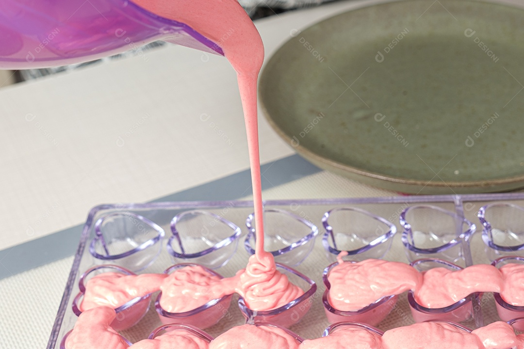 Ganache de morango sendo despejada em forma de policarbonato