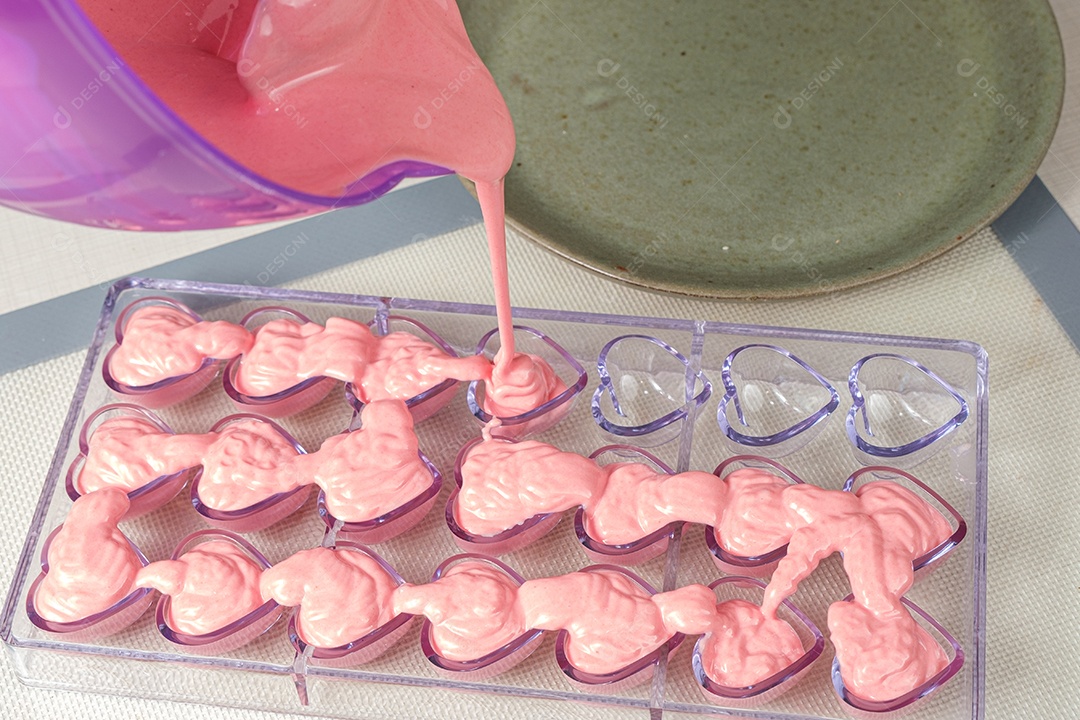 ganache de morango sendo derramado em forma de coração de policarbonato