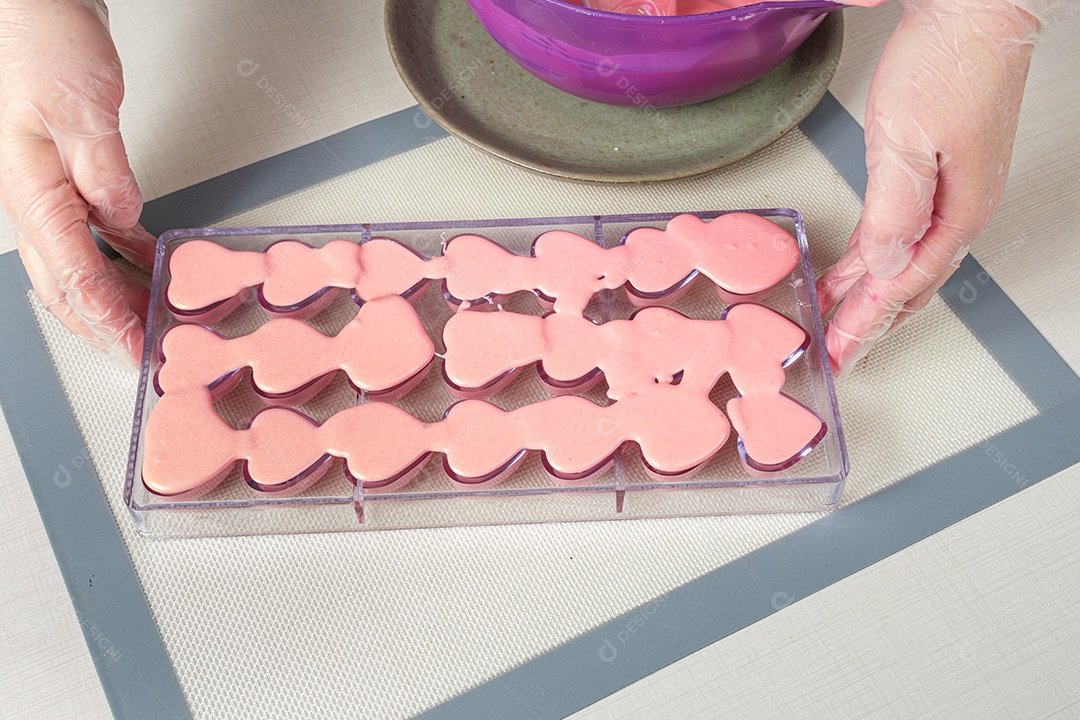 Confeiteiro servindo uma forma de policarbonato recheada com ganache de morango