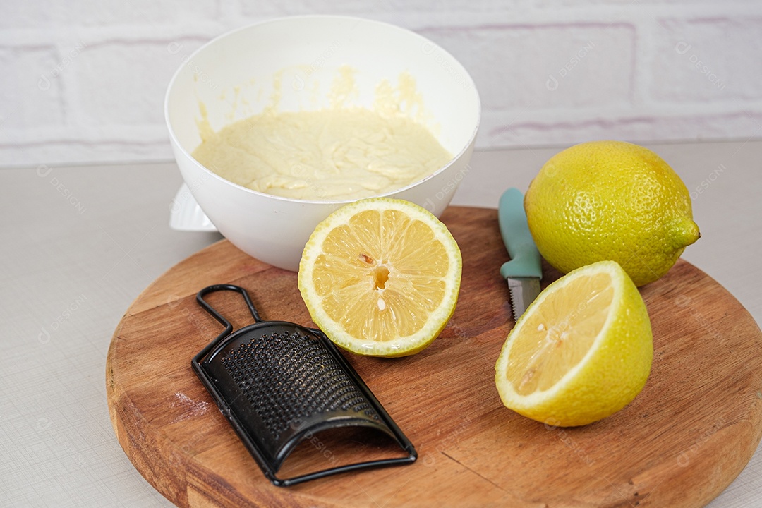 Limão siciliano cortado ao meio ao lado de um ralador e uma cápsula com ganache de chocolate branco.