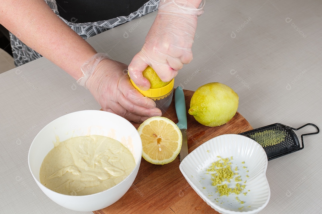 Confeiteiro espremendo limão para misturar, junto com as raspas, na ganache de chocolate branco.