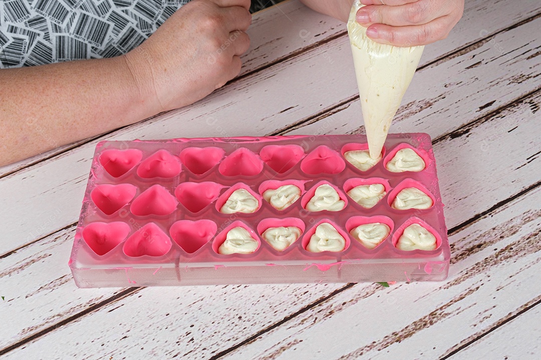 confeiteira um bico de confeiteiro para rechear chocolates com ganache de chocolate branco