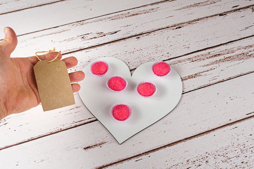 Porção de bicho de pe sobre tábua de madeira em forma de coração. Doce Tradicional Brasileiro