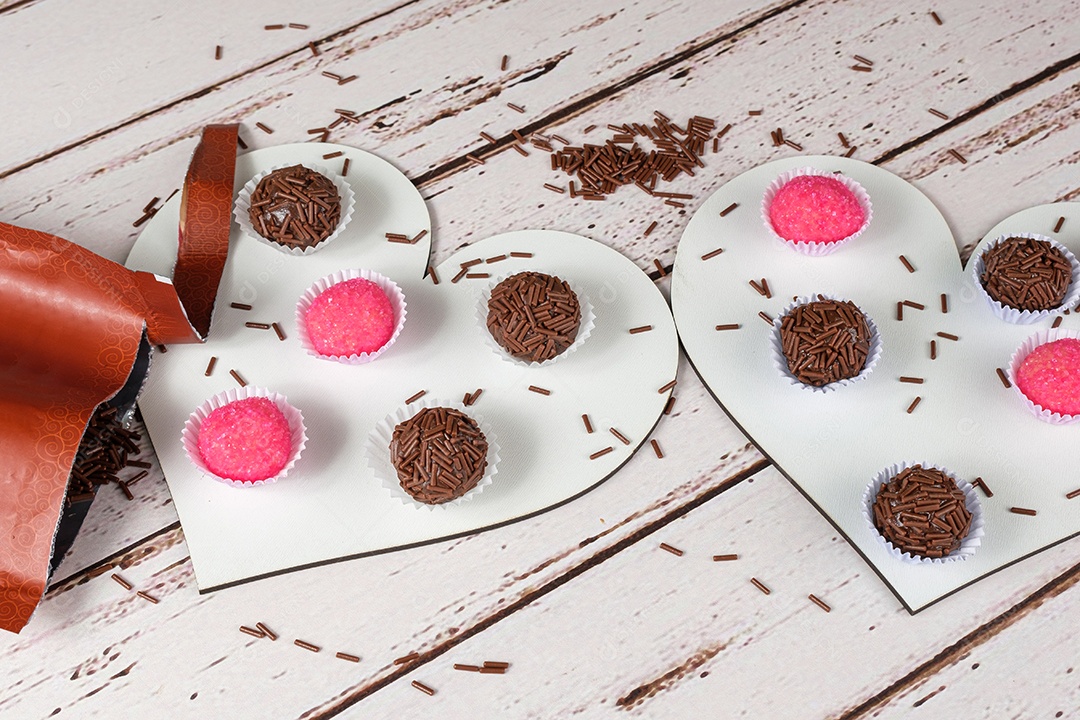 Brigadiers and animals standing on heart-shaped plates next to a packet of chocolate sprinkles