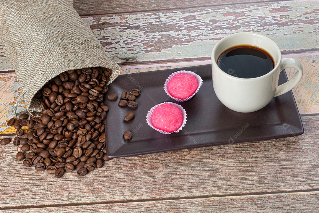 Brigadeiros bichos de pé ao lado de uma xícara e grãos de café.