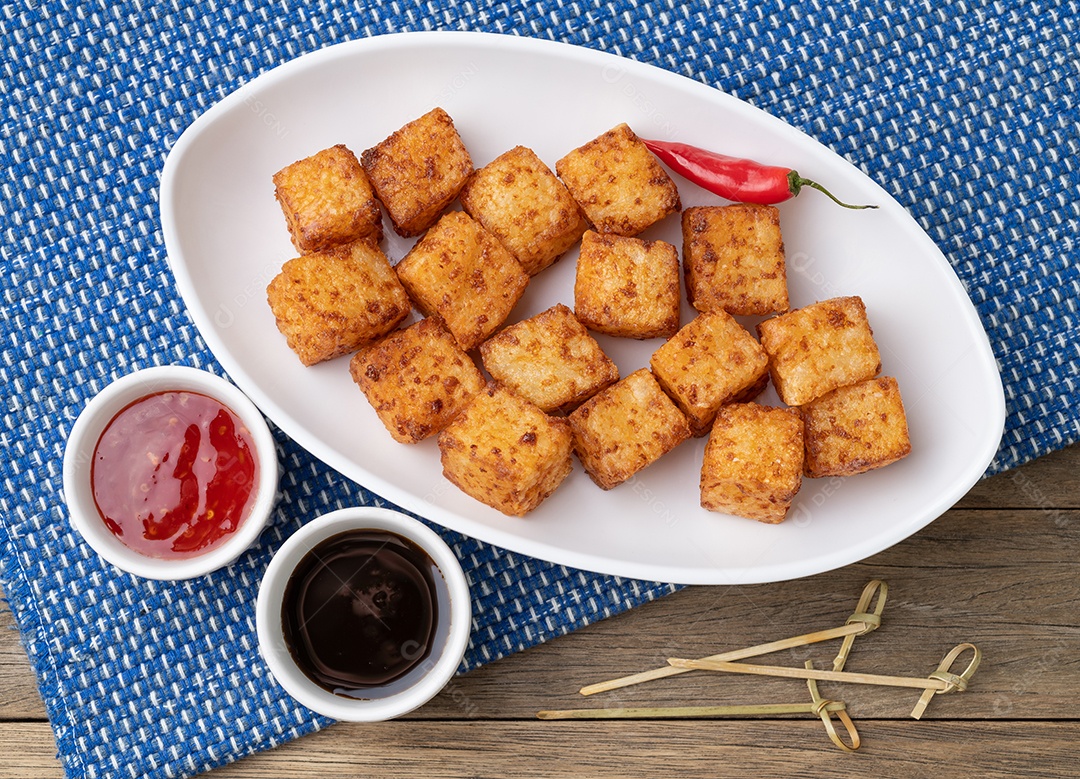 Dado de tapioca, comida típica do nordeste brasileiro isolado sobre fundo mesa madeira.