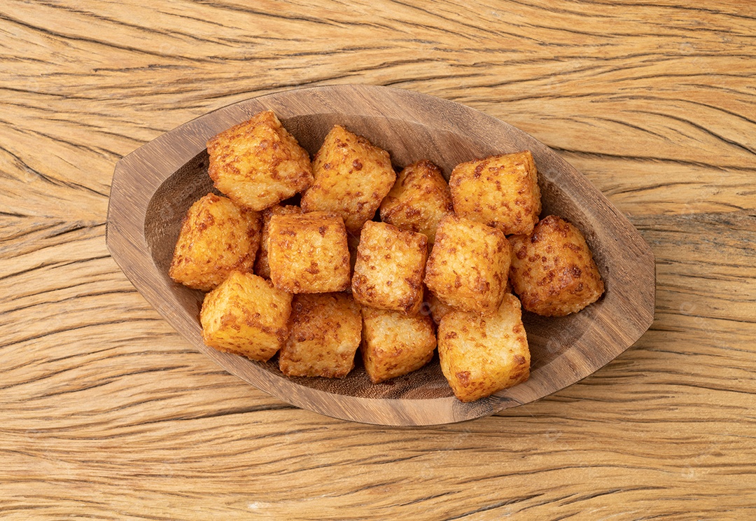 Dado de tapioca, comida típica do nordeste brasileiro sobre a mesa de madeira.