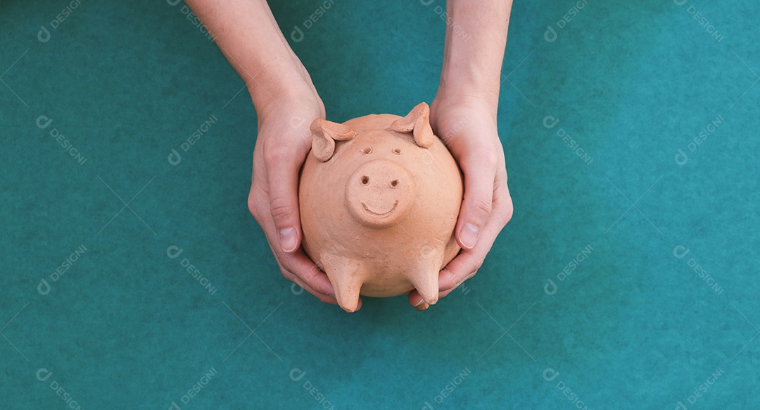 Porco com moedas brasileiras isoladas em fundo azul