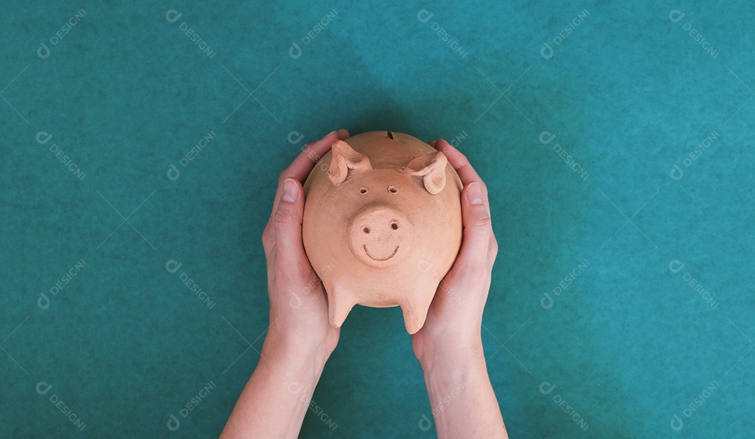 Porco com moedas brasileiras isoladas em fundo azul