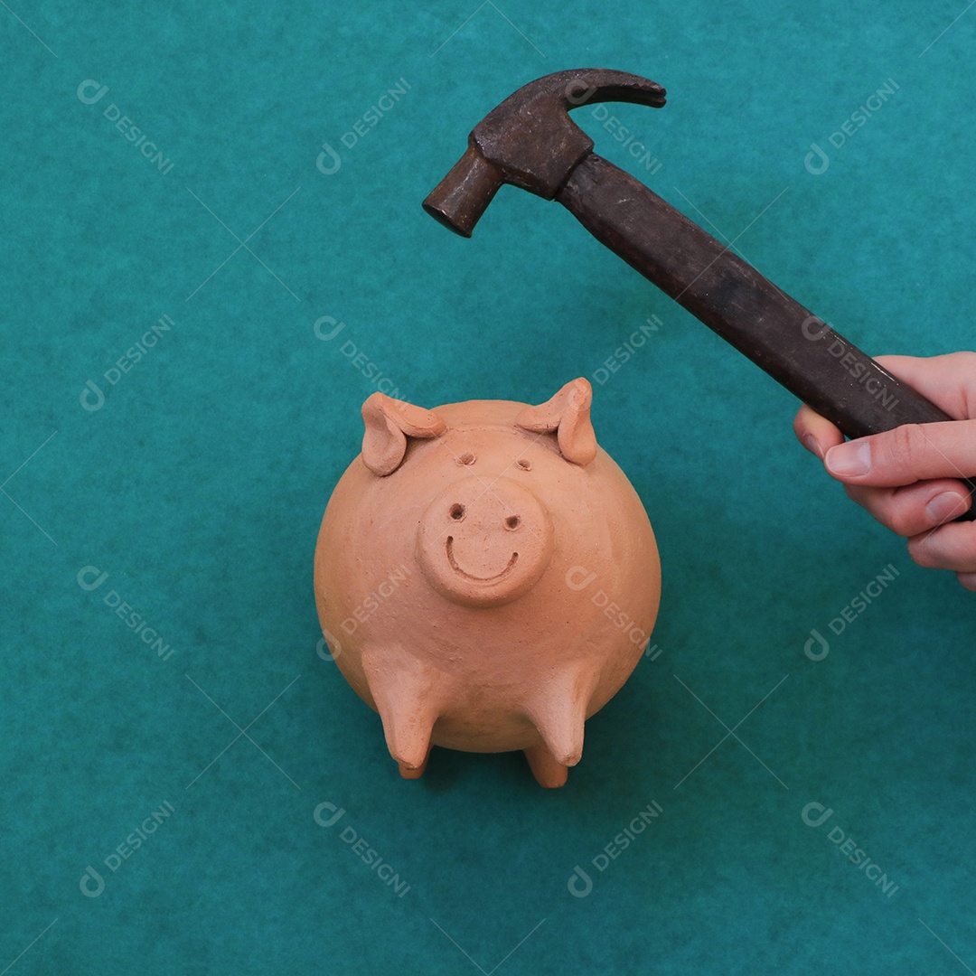 Hand holding pig coin breaking hammer isolated on green background
