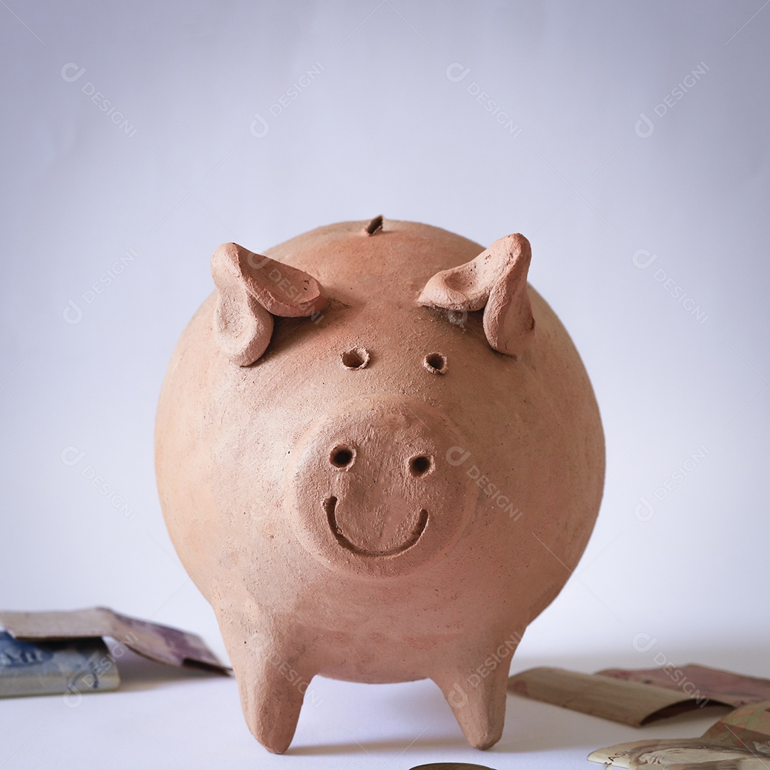 Porco com moedas brasileiras isoladas em fundo branco