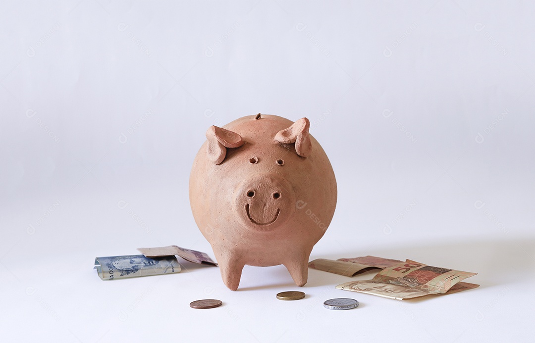 Porco com moedas brasileiras isoladas em fundo branco
