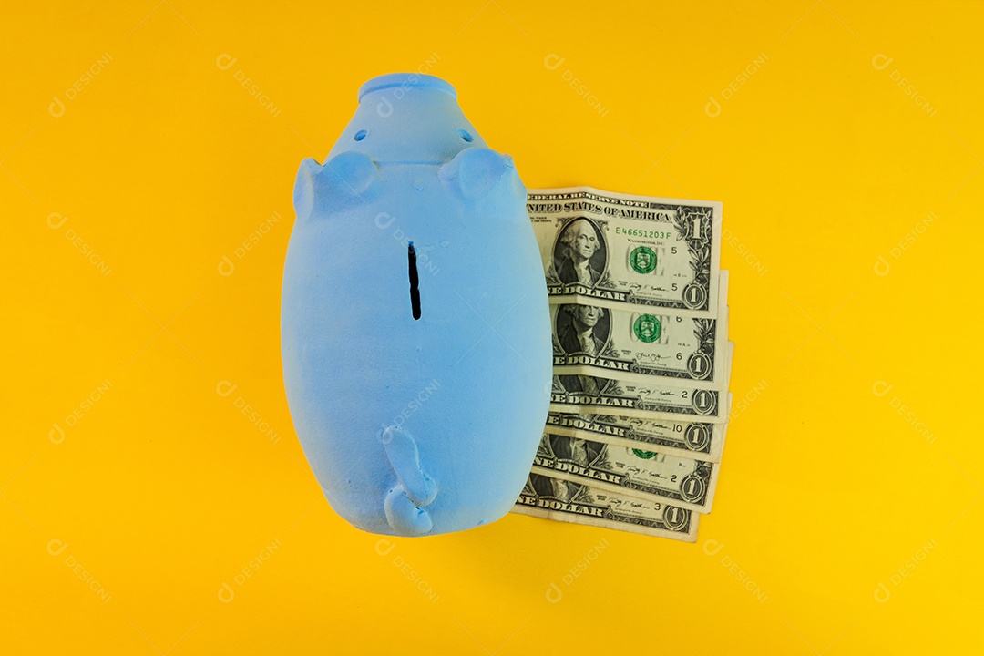 Porco com moedas brasileiras isoladas em fundo amarelo